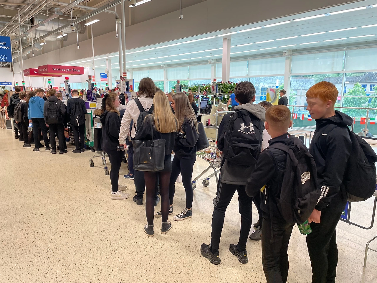 슈퍼마켓에서 간식 계산을 위해 줄을 서는 청소년.JPG