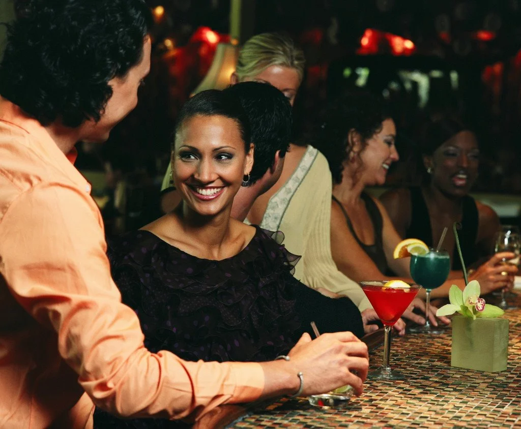 woman-sitting-at-bar-with-others-87781542.jpg?type=w1200