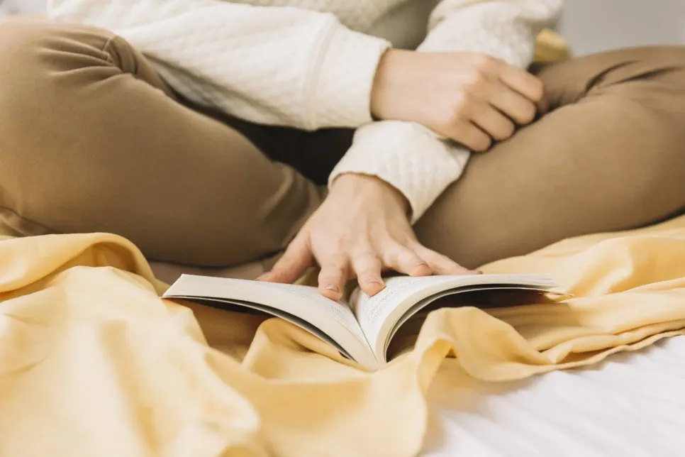 crop-woman-sitting-bed-reading.jpg?type=w966