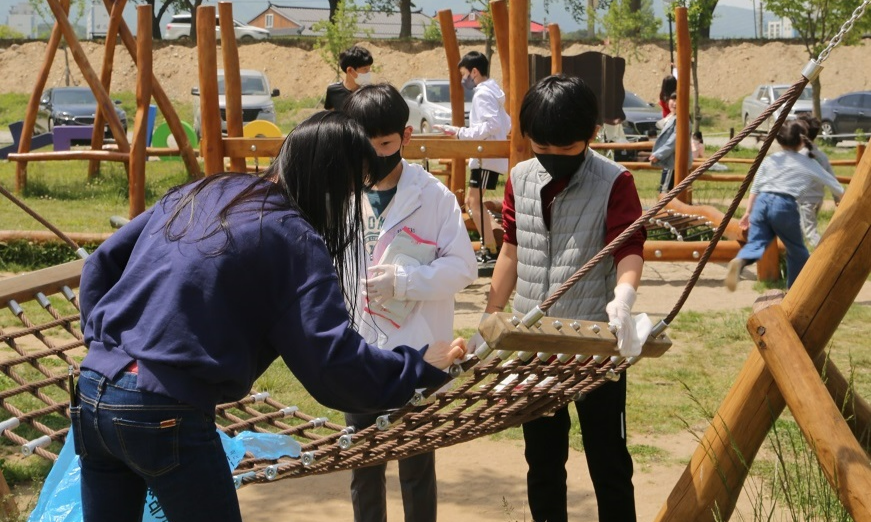YOUTH 자원봉사 아이디어 공모사업 사진, 어린이들이 공원을 놀이기구를 소독하고 있다.