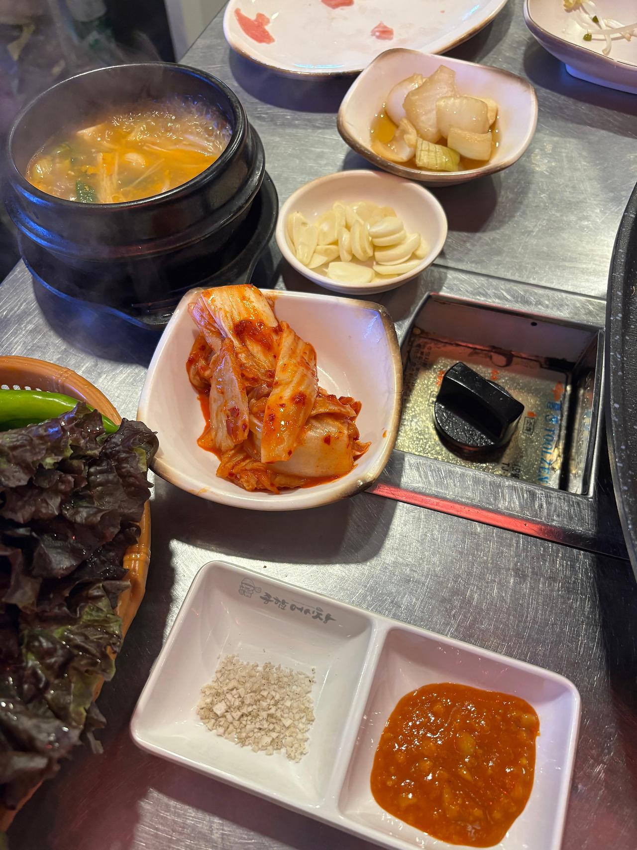 된장찌개와 김치, 양파절임, 마늘 등 다양한 기본 반찬들