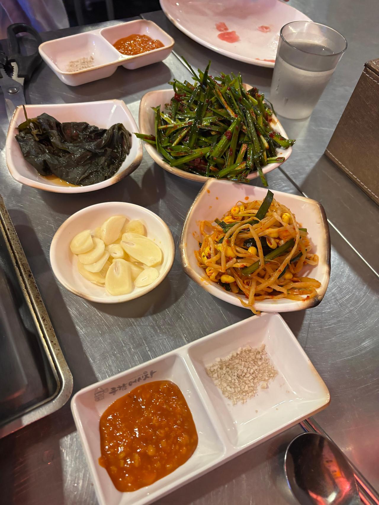깻잎, 부추, 콩나물 등 반찬이 다양하게 놓인 테이블