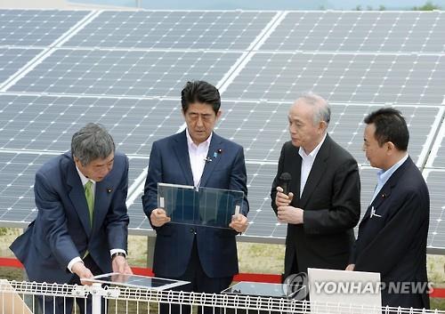 아베 신조(安倍晋三, 왼쪽 두 번째) 일본 총리가 2015년 5월 31일 일본 후쿠시마(福島)현 고리야마(郡山)시에 있는 후쿠시마 재생가능 에너지 연구소를 방문해 태양광 발전 설비에 관한 설명을 듣는 모습.(교도=연합뉴스)