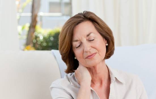 목에 통증을 느끼는 중년여성