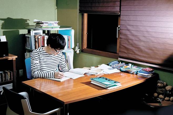 정성욱군이 자기 방 책상에서 영어 지문을 외우고 있다. 답답한 걸 싫어하는 정군은 독서실이나 자율학습실보다 시야가 트인 책상이 있는 집에서 공부하는 걸 선호한다.