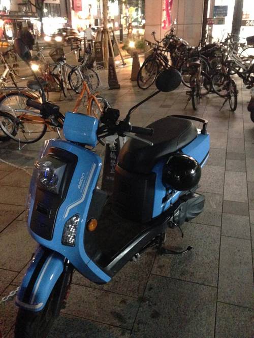 대만 브랜드 AEON의 상큼한 스쿠터가 슈퍼마켓 앞에 서 있었습니다.