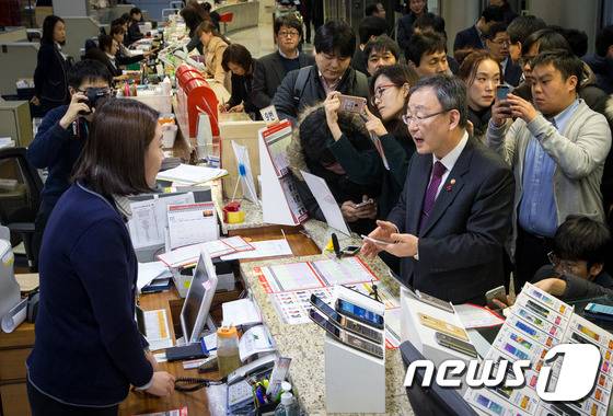 최성준 방송통신위원장이 13일 오후 서울 중구 서울중앙우체국 알뜰폰 판매현장을 방문해 알뜰폰을 살펴보고 있다. 2016.1.13/뉴스1 © News1 구윤성 기자