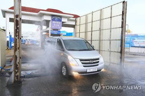 제주도 구제역 예방에 비상     (제주=연합뉴스) 박지호 기자 = 전북 김제에서 구제역이 발생해 방역당국이 긴급 살처분과 방제활동에 돌입한 가운데 13일 오전 제주항을 나서는 차량이 방역초소를 지나고 있다. 2016.1.13     jihopark@yna.co.kr