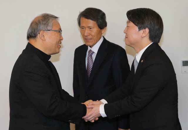 안철수 의원(오른쪽)이 14일 오전 서울 명동성당을 방문해 염수정 추기경(왼쪽)과 악수를 하고 있다. 가운데는 한상진 국민의당 공동창당준비위원장. 공동취재사진