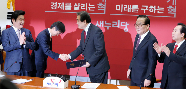 더불어민주당을 탈당한 조경태 의원(가운데)이 21일 국회 새누리당 대표실에서 열린 최고위원회의에 참석해 김무성 대표에게 입당원서를 건넨 뒤 인사하고 있다.  김경호 선임기자