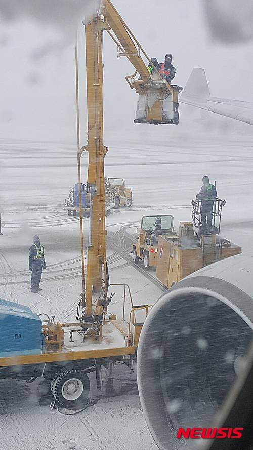 【제주=뉴시스】조명규 기자 = 23일 오후 제주산간 지역에 대설경보가 내려진 가운데 제주공항에서 공항 관계자들이 비행기 날개에 붙어 있는 눈과 얼음을 제거하고 있다. 2016.01.23   mkcho@newsis.com