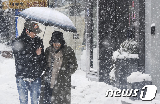 광주 전남지역이 15년만에 가장 추운 날씨를 보인 24일 광주 동구 금남로에서 시민들이 쏟아지는 눈을 피하며 길을 걷고 있다. 광주지방기상청은 이날 광주 -11.7도, 해남 -9.8도, 목포 -9.1도 등 올 겨울 들어 최저 기온을 예보했다. 2016.1.24/뉴스1 © News1 황희규 기자
