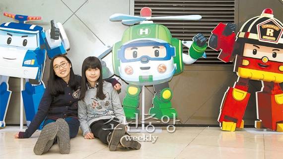 `로보카 폴리` 등의 로봇 애니메이션이 상영되는 미니상영관 앞에 체험평가단이 캐릭터들과 함께 앉아 있다.