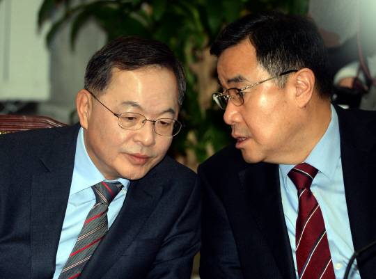 안대희 첫 참석 : 25일 오전 국회에서 열린 새누리당 최고위원회의에 지명직 최고위원으로 처음 참석한 안대희(왼쪽) 전 대법관이 김정훈 정책위의장과 귀엣말을 나누고 있다.  김선규 기자 ufokim@
