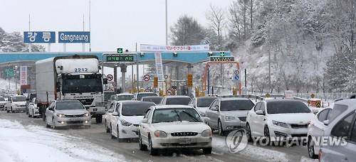 (강릉=연합뉴스) 유형재 기자 = 설 연휴 첫날인 6일 강원 동해안에서 폭설이 내린 가운데 영동고속도로 강릉 나들목을 빠져나온 귀성 차들이 조심스럽게 운행하고 있다. 2016.2.6 yoo21@yna.co.kr (끝)