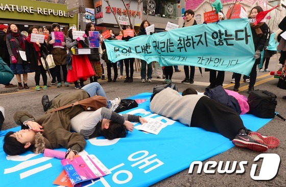 한국성폭력상담소 회원들이 14일 서울 신촌로 차 없는 거리에서 동의없는 성폭력을 반대하는 캠페인을 하며 술과 약물을 이용한 성폭력을 방지하기 위한 만취 퍼포먼스를 하고 있다.  2016.2.14/뉴스1 © News1 손형주 기자