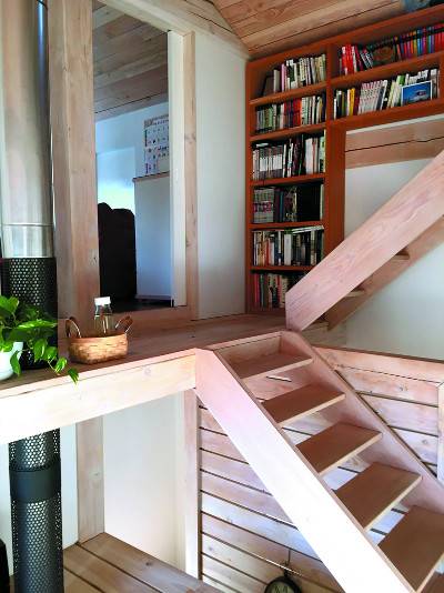 같은 층이면서 단 차이가 나는 실내 공간들이 작은 목조 계단으로 이어져 있는 집 내부.