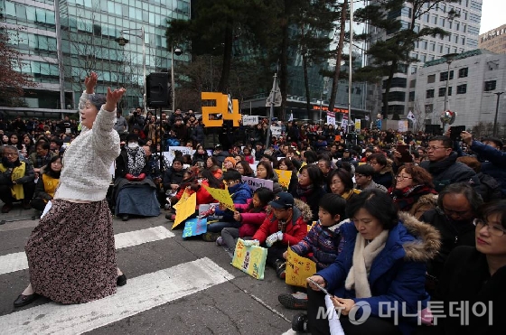 6일 오후 서울 종로구 옛 일본대사관 앞에서 열린 제1212차 일본군 위안부 문제해결을 위한 정기수요집회 한일 위안부 협상 규탄 집회에서 한 예술인이 퍼포먼스를 벌이고 있다.이날 올해로 24주년을 맞은 수요집회에는 위안부 피해자 이용수 할머니와 야당 국회의원, 시민사회단체, 대학생 등 각계의 다양한 사람들이 참여했다.
