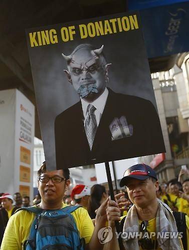 나집 총리를 비판하는 포스터를 들고 항의시위 중인 시민들 [EPA=연합뉴스]