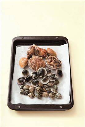 2. 오븐팬에 종이호일이나 쿠킹호일을 깔고 조개를 얹는다.