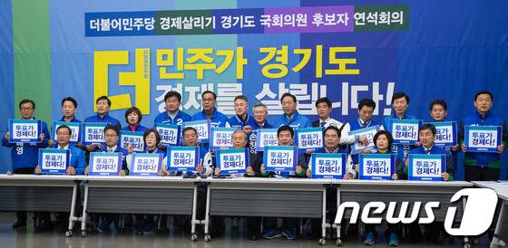 김종인 더불어민주당 비상대책위원회 대표를 비롯한 경기도 국회의원 후보자들이 30일 경기도의회 대회의실에서 열린 더불어민주당 경제살리기 경기도 국회의원 후보자 연석회의에서 '투표가 경제다!'라고 쓰여진 손팻말을 들고 구호를 외치고 있다. 2016.3.30/뉴스1 © News1 유승관 기자
