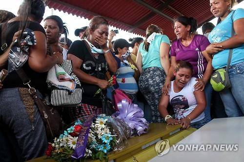 지난 3월 갱단에 살해된 광부들의 관 옆에서 오열하는 유족들 [EPA=연합뉴스 자료사진]