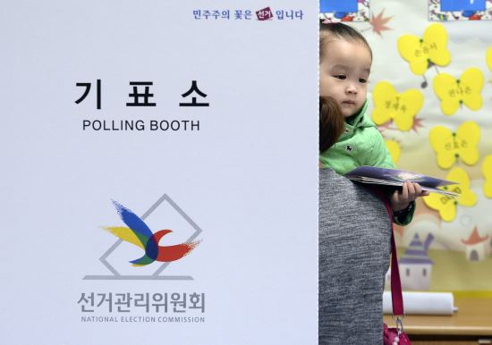 사진=제20대 국회의원 선거일인 13일 오전 서울 용산구 한남초등학교에 마련된 한남동 제3투표소에서 한 어린이가 엄마와 함께 투표를 하고 있다. 뉴시스.