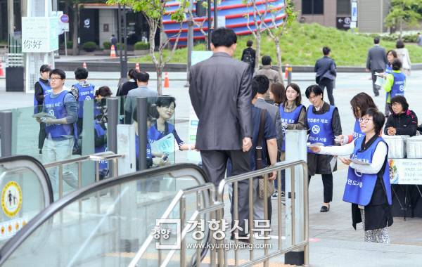 2일 서울 광화문 지하철역 출입구 앞에서 서울시청 공무원들이 전날부터 시행된 ‘지하철역 10m이내 금연’을 알리는 안내물을 시민들에게 나눠주고 있다.   이준헌 기자