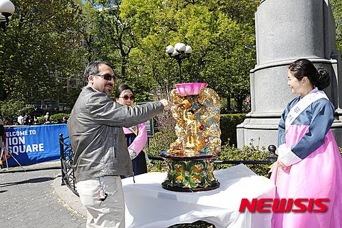 【뉴욕=뉴시스】노창현 특파원 = 대한불교조계종 미동부 해외특별교구가 8일 맨해튼 유니온스퀘어 파크에서 뉴욕 뉴저지 일원 스님들과 타민족 불교국가 스님들, 동포 불자들 400여명이 함께 한 가운데 부처님오신날을 기념하는 국제봉축법요식 및 제등행렬을 했다. 이날 행사는 불자들과 현지인들이 아기부처님 몸을 씻기우는 관불의식을 시작으로 1부 동포 불자 아티스트들의 공연, 2부 부처님오신날 기념 법요식, 3부 제등행렬, 4부 폐막식 순으로 이어졌다. 한 뉴요커가 아기부처님의 몸을 씻기우는 관불의식에 참여하고 있다. 2016.05.09. <사진=미동부해외특별교구 제공>   robin@newsis.com