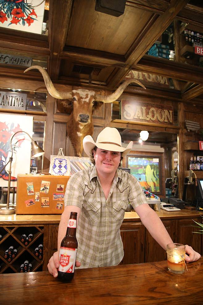 잡화점 매버릭에서 카우보이 복장을 하고 맥주를 파는 점원.