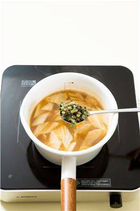 4. 국물이 끓으면 배추 잎, 고춧가루, 다진 마늘을 넣어 10분 정도 끓이다가 다슬기를 넣는다. 부추와 대파를 넣고 살짝 끓여 소금으로 간한다.