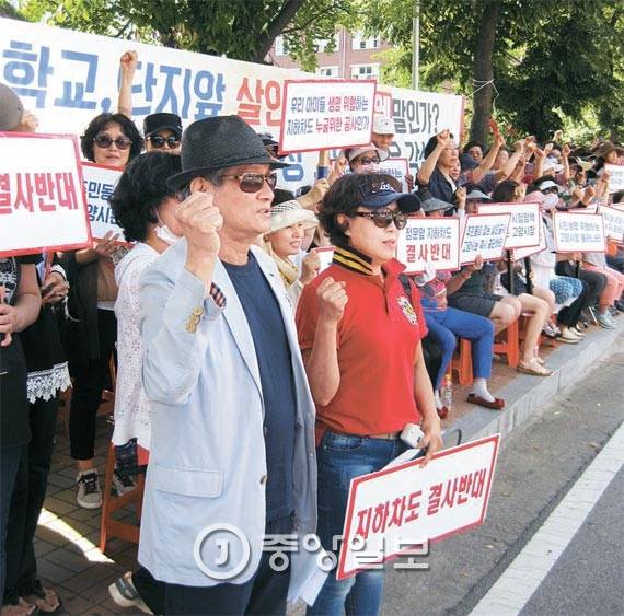 백마4단지 주민들이 아파트 단지 입구 도로변에서 공사 중지를 촉구하며 시위하고 있다. [사진 전익진 기자]