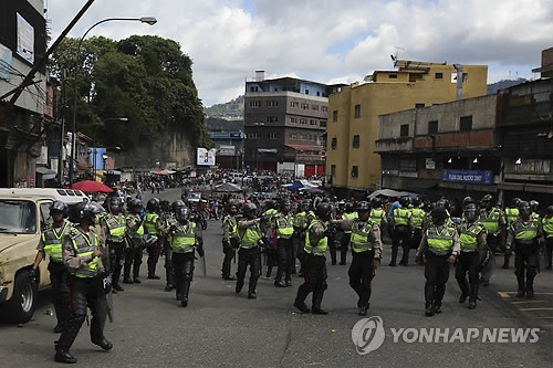 경제난 베네수엘라, 기초식품 국가배급 추진 (카라카스 AP=연합뉴스) 베네수엘라 정부는 극심한 경제난으로 약탈이나 쓰레기 뒤지기 등의 현상까지 발생하자 9일(현지시간) 기초식품 국가배급제를 추진하겠다고 밝혔다. 이에 대해 야권은 성난 민심을 달래기 위한 선심성 정책으로 굶주림 현상이 더 심화할 것이라고 비난했다. 사진은 이날 수도 카라카스의 슬럼가 페타레 지역에서 약탈이 잇따르자 대규모 경찰 병력이 출동, 중심광장을 통제하고 있는 모습.