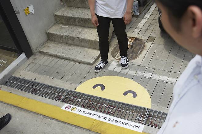 지난 6일 서울 마포구 홍대 인근에 있는 빗물받이 하수구에도 `씩~ 웃는 스마일` 스티커를 부착했다. [제임스 요한슨 객원 사진작가]