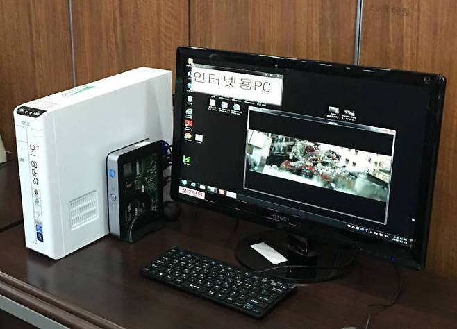 업무용 PC(흰색)와 함께 인터넷용으로 설치된 인프론티브 테트라 미니PC. 작은 크기에 KVM 스위치가 내장돼 있어 효율적인 공간 관리가 가능하다.