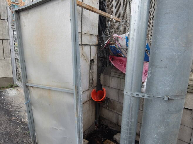 공사장에서 가져온 원뿔형 깔때기를 꽂고 공사장 알림판으로 가린 한남상운 마을버스 운전기사들의 화장실.
