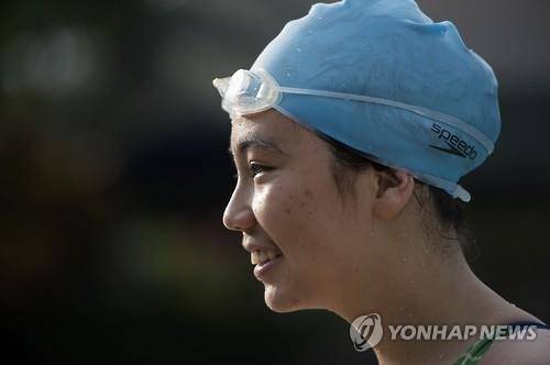 리우올림픽에 출전하는 라오스 여자수영 국가대표 사리 버차레른 아룬(14)이 라오스 비엔티안에서 훈련을 마친 뒤 환하게 웃고 있다. (AFP=연합뉴스)