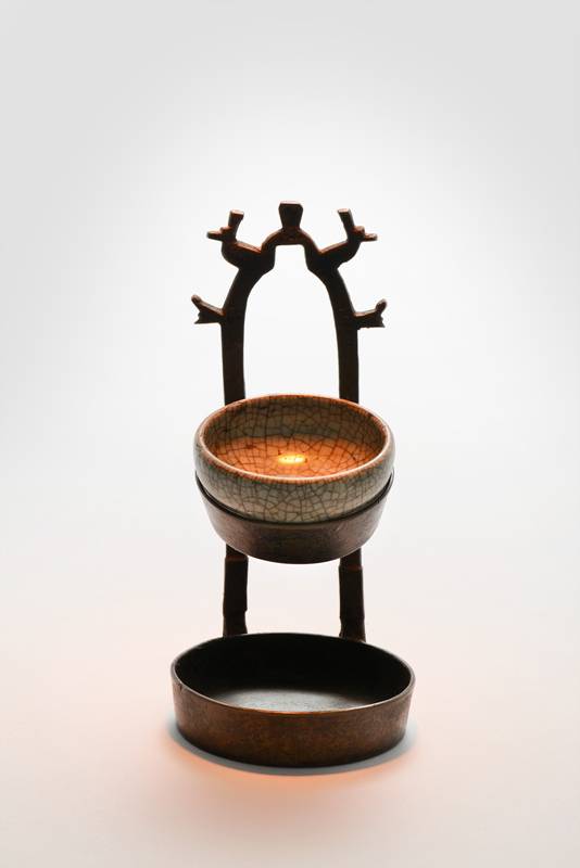 벽걸이 등. 등잔받침 아래 기름찌꺼기를 받는 기름받이가 있다. 걸쇠 장식은 새, 나무, 기하학적 무늬를 단순화한 모양이다.