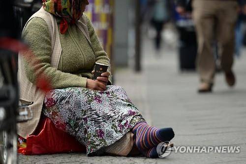 유럽의 한 도시에서 구걸행위를 하고 있는 여인(자료사진)