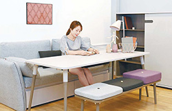 신미영 디자이너가 실용적인 구조의 테이블·책장을 활용해 가족을 위한 거실 서재로 꾸민 ‘리브레 시리즈’에서 책을 읽고 있다.