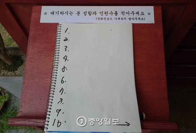 대기자 이름 적는 명부 위에 전화번호는 기재하지 말라고 씌어있다.