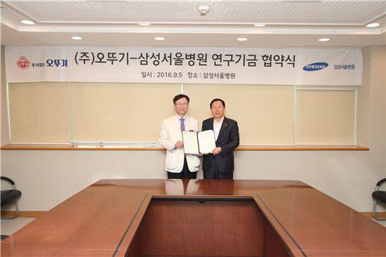 오뚜기-삼성서울병원 연구기금 협약식에서 권오정 삼성서울병원 원장과 이강훈 오뚜기 사장(오른쪽)이 기념촬영을 하고 있다.