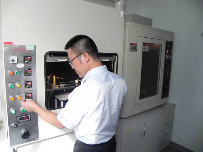 KTL 중국 시험소에 있는 글로우 와이어(glow-wire) 테스트 기기를 직원이 조작하고 있다.