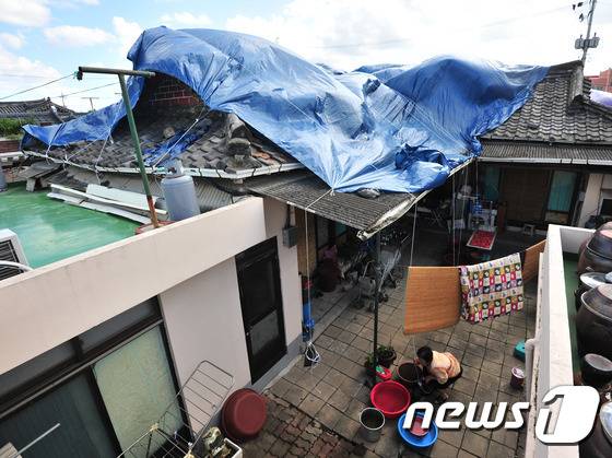 19일 저녁 경북 경주에서 규모 4.5의 지진이 발생해 주민들의 불안감이 커지고 있는 가운데 20일 오전 경주시 사정동 한옥 주택에 덮여 있는 비가림 천막이 강풍에 바람에 날리고 있다. 이번 여진은 국내 최대 규모 5.8의 지진이 발생한 지 1주일 만이다.2016.9.20/뉴스1 © News1 최창호 기자