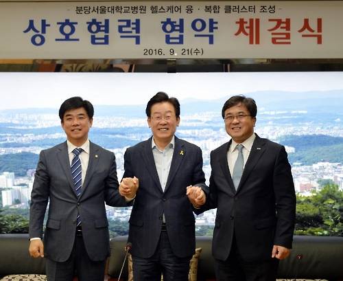 (성남=연합뉴스) 이재명 성남시장(가운데)과 전상훈 분당서울대병원장(오른쪽), 김병욱 국회의원이 21일 헬스케어 융복합 클러스터 조성 협약을 체결한 뒤 손을 맞잡고 기념사진을 촬영하고 있다. 2016.9.21 [성남시 제공]