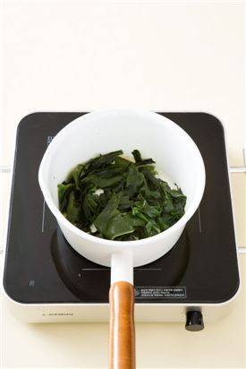 3. 냄비에 참기름을 두르고 미역을 넣어 2분 정도 볶는다. 이어서 물 2컵을 넣고 센 불에 5분 정도 끓인다.