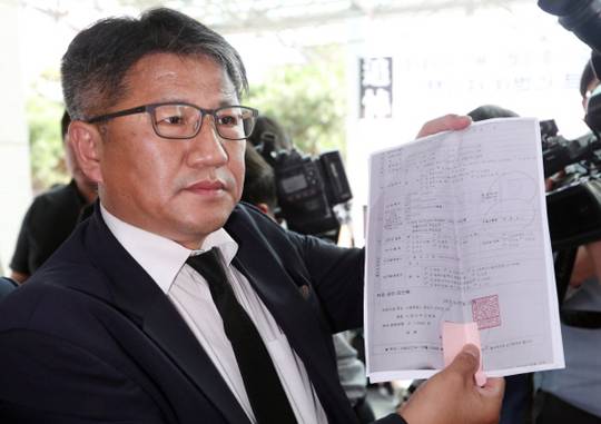 Baek\'s Death Certificate: On the afternoon of October 4, attorney Jo Yeong-seon, the legal representative of the bereaved family of Baek Nam-gi holds and displays Baek\'s death certificate in front of the funeral home at Seoul National University Hospital. Yonhap News