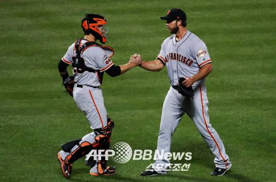 샌프란시스코 자이언츠의 매디슨 범가너(오른쪽)와 포수 버스터 포지가 6일(한국시각) 열린 뉴욕 메츠와의 내셔널리그 와일드카드 결정전서 완봉승을 거둔 뒤 악수를 나누고 있다.ⓒAFPBBNews = News1