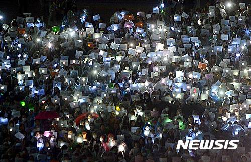 【서울=뉴시스】조성봉 기자 = 7일 오후 서울 서대문구 이화여자대학교에서 열린 최경희 총장 사퇴 촉구 3차 총시위에서 재학생과 졸업생들이 손피켓과 핸드폰을 들고 ‘최경희 총장 사퇴’를 요구하고 있다. 2016.10.07.   suncho21@newsis.com