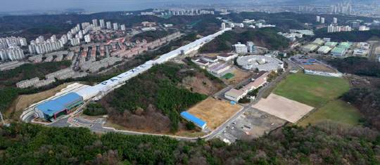 포스텍에 건설된 4세대 방사광가속기 전경. 대각선 방향으로 뻗은 1.1㎞의 건물 안에 전자를 가속시키는 선형 가속관이 설치돼 있다. 오른쪽 둥근 건물은 3세대 방사광가속기.